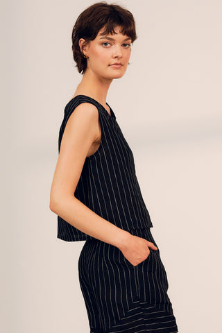Side view of woman wearing a linen black and white strip Tenaya top by Jennifer Glasgow.