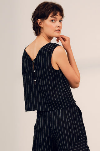 Back view of woman wearing a linen black and white strip Tenaya top by Jennifer Glasgow.