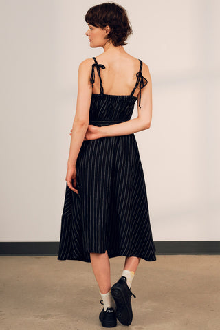 Woman wearing black stripe linen strappy Terra summer dress by Jennifer Glasgow. 