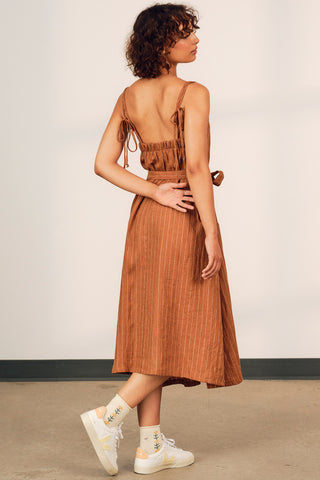 Woman wearing ochre stripe linen strappy Terra summer dress by Jennifer Glasgow. 