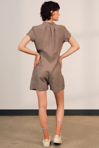 Back view of model wearing grey OEKO-TEK linen Thalassa jumpsuit by Jennifer Glasgow. 