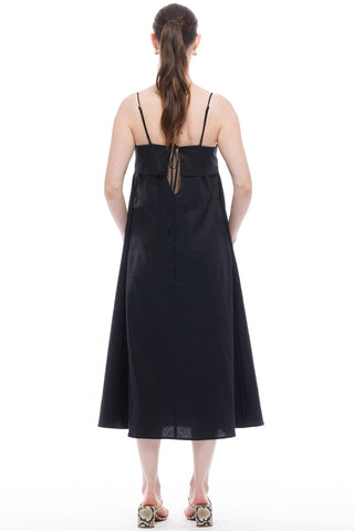 Back view of woman wearing black midi length spaghetti strap Verona Dress by Toit Volante. 