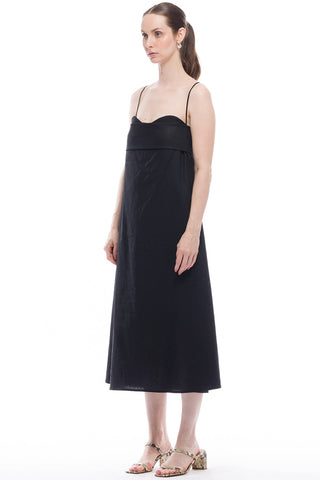 Side view of woman wearing black midi length spaghetti strap Verona Dress by Toit Volante. 