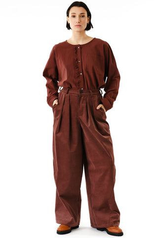Woman in front of white background wearing brown button up shirt tucked into brown corduroy wide leg Zohrah pants by Jennifer Glasgow. 