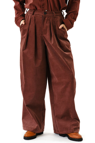 Close-up of woman in front of white background wearing brown corduroy wide leg Zohrah pants by Jennifer Glasgow. 