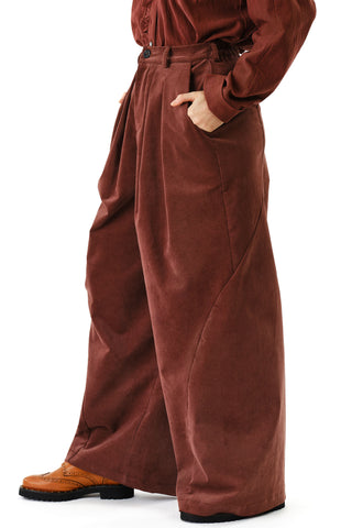 Close-up side view of woman in front of white background wearing brown corduroy wide leg Zohrah pants by Jennifer Glasgow. 