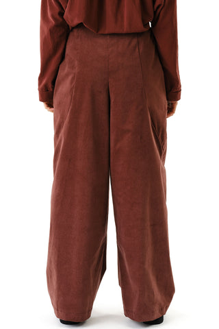 Close-up of back view woman in front of white background wearing brown corduroy wide leg Zohrah pants by Jennifer Glasgow. 