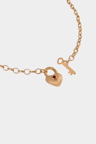 Gold necklace with heart lock and key charm on a white background