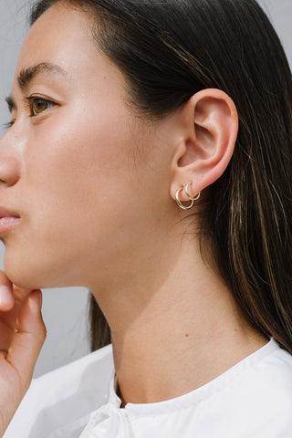Model wearing Kara Yoo Halow Faux Double Hoop earrings in sterling silver. 