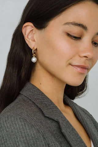 Model wearing gold vermeil Uma Hoop earrings with wrinkle pearl charm by Kara Yoo. 