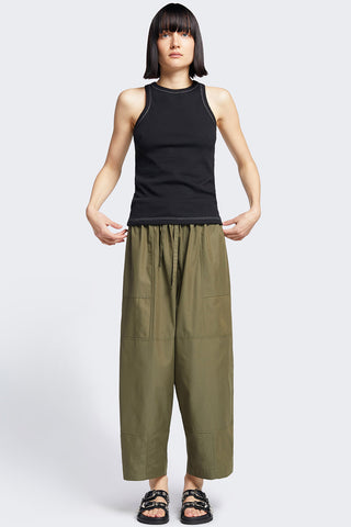 Woman wearing black tank top and olive wide leg patch pocket Aratus Pants by Kloke. 