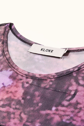 Close-up of flat lay photo of purple Inlet top by Kloke on white background. 