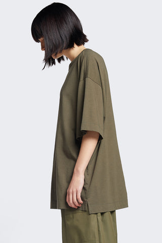 Side view of woman wearing olive oversized unisex organic cotton Monolith tshirt by Kloke. 