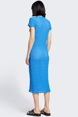 Back view of woman wearing blue knit short sleeve midi Trove dress by Kloke. 