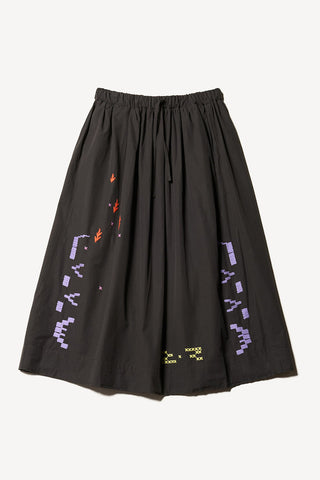 Flat lay photo of black Universe skirt by Kloke with colourful embroidery. 