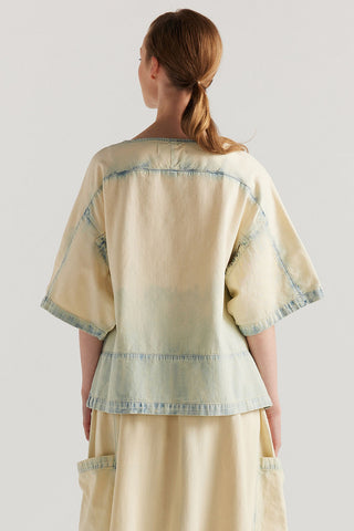 Back view of woman wearing faded denim relaxed fit top with matching drawstring waist skirt. 