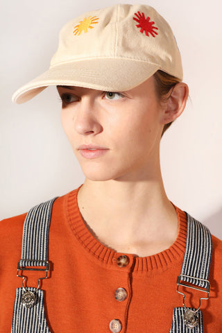 Woman wearing ecru LF Markey Sunny baseball cap with all over embroidered suns. 