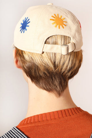 Woman wearing ecru LF Markey Sunny baseball cap with all over embroidered suns. 