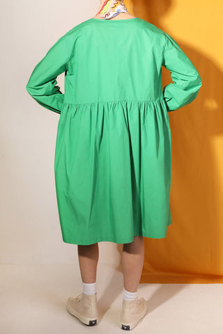 Back view of woman wearing green poplin babydoll Warren dress by LF Markey. 