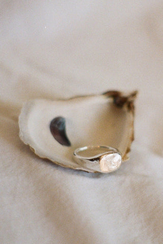 Sterling silver signet ring in oyster shell. 