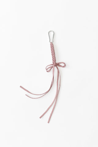 Taupe pink crocheted bag charm on white background. 