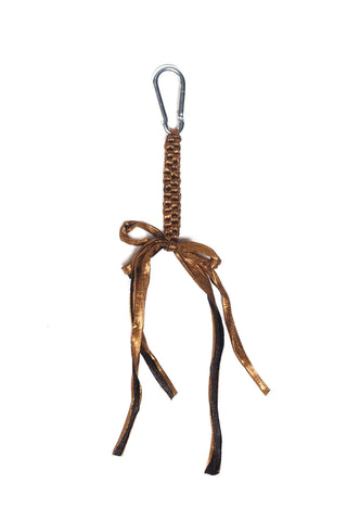Metallic bronze crocheted bag charm on white background. 