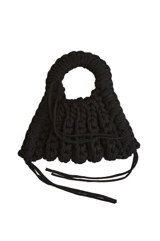 Black crocheted handbag in front of white background. 