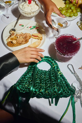 Metalic green crocheted bag on festive table. 