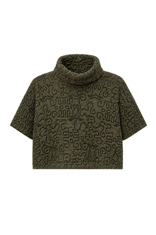 An olive green short-sleeve turtleneck sweater featuring an all-over abstract quilted pattern, shown against a plain white background.