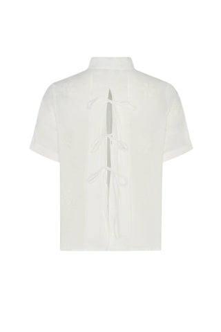 Back of white blouse with a high neckline on a white background