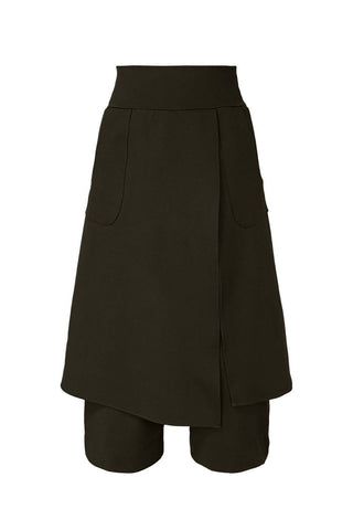 Black pants with asymmetrical attached skirt panel, against white background. 