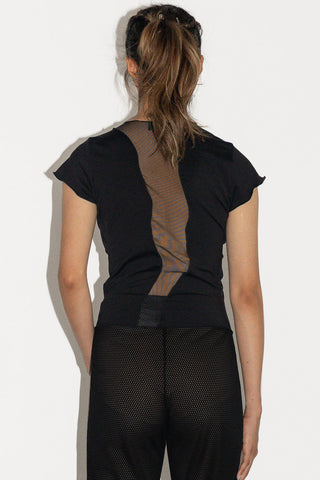 Woman in front of white background wearing black cap sleeve top with mesh insert detail on back.