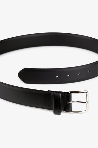 Black leather belt with rectangular silver buckle, against white background. 