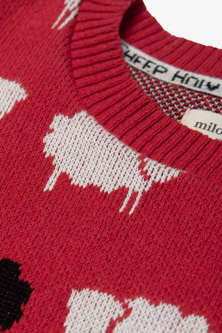 Close-up of red recycled cotton knit sweater with all over sheep pattern. 