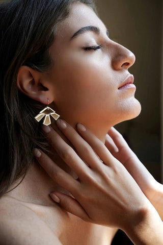 Side profile of woman wearing silver mirror Lotus earrings by Mim Té. 