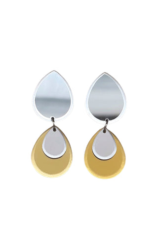 A pair of double teardrop-shaped drop earrings made from silver and gold plexiglass, shown on a plain white background.