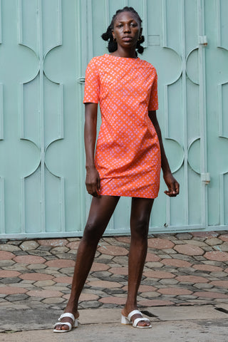 Model wearing orange and pink Sugar Cube print Muto dress by Osei Duro. 