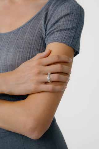 Close-up of person wearing grey t-shirt and sterling silver ring. 