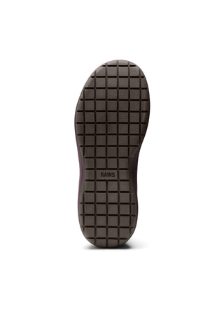 A single shoe sole viewed from the bottom, showing a dark brown textured rubber tread with a grid pattern and the brand name 'RAINS' printed in the center, isolated on a white background.