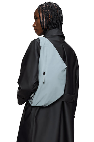 Person wearing black jacket and light blue waterproof oversized Bum Bag. 