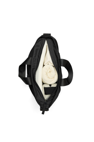 An overhead view of an open black tote bag, set against a plain white background.