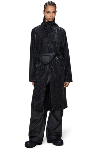 Woman wearing long black rain jacket with black fanny pack. 