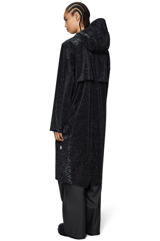 Back view of person wearing long black hooded rain jacket. 