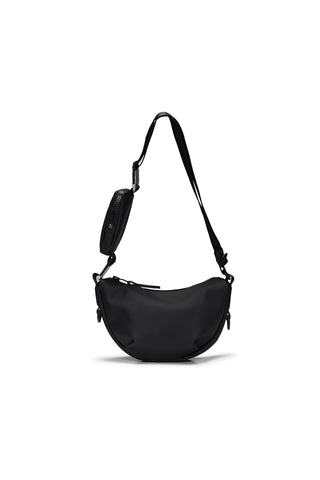 Black over the shoulder or cross-body bag with pouch on strap in front of white background. 