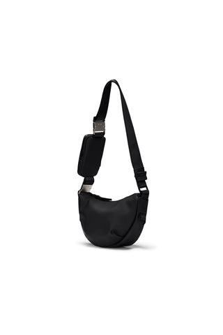 Black over the shoulder or cross-body bag with pouch on strap in front of white background. 