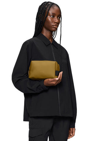 Woman holding camel waterproof toiletry bag. 