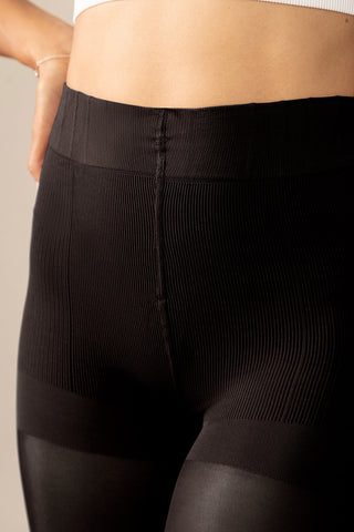 Close-up of black contour-shaping waistband on tights. 