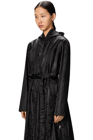 Close-up of woman wearing shiny black Aline Longer Jacket by RAINS. 