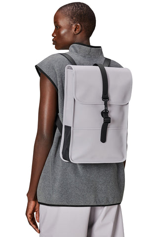 Woman wearing minimal flint grey waterproof Backpack Mini W3 by Rains. 
