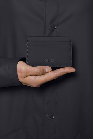 Hand holding black waterproof Cardholder by Rains. 